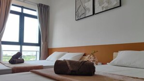Una camera d'albergo con due letti, un'ampia finestra e opere d'arte alle pareti.