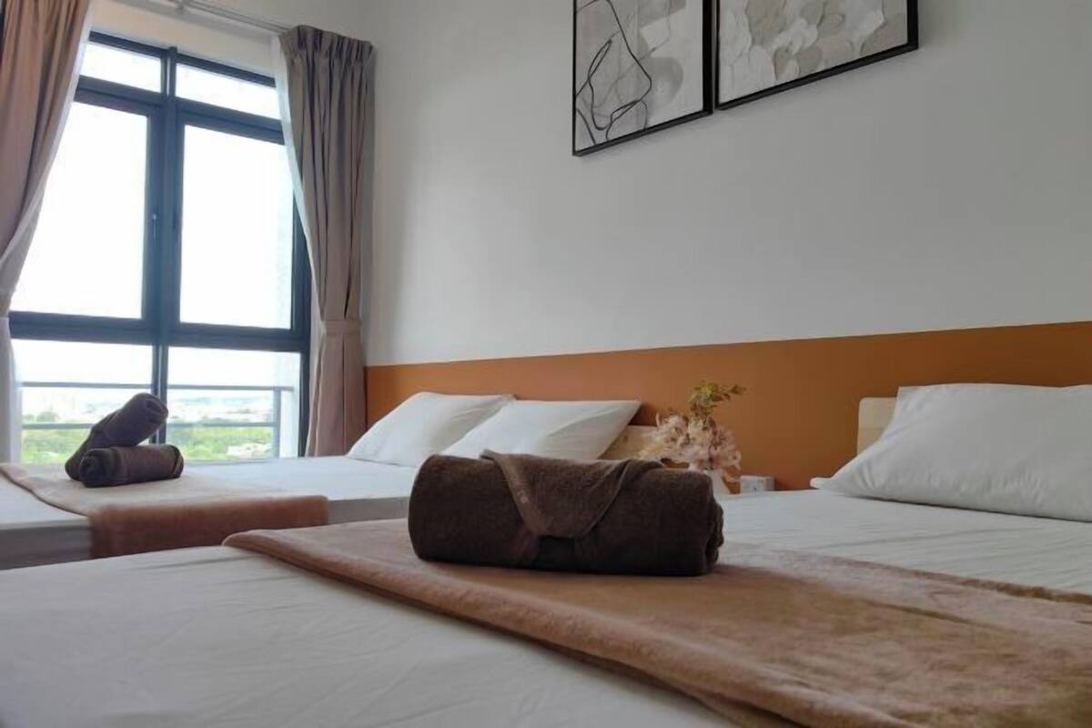 A hotel room with two beds, a large window, and artwork on the wall.