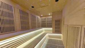 Una moderna spa con pareti e soffitto in listelli di legno, una panca al centro e un pavimento decorato.