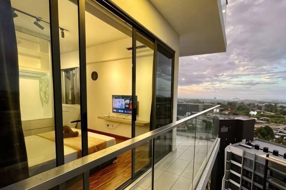A modern interior with a glass partition, a flat-screen TV, and a city view.