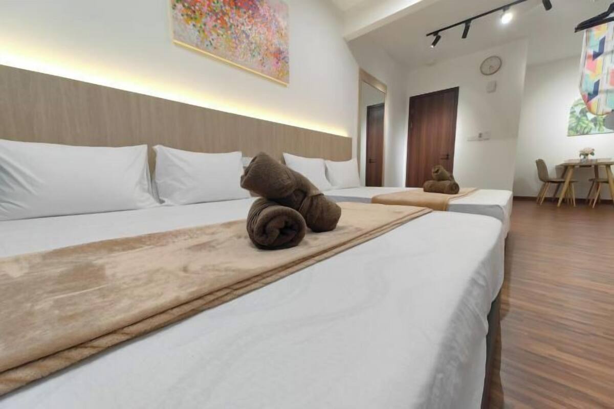 A hotel room with a large bed, a wooden headboard, a desk, and a chair.
