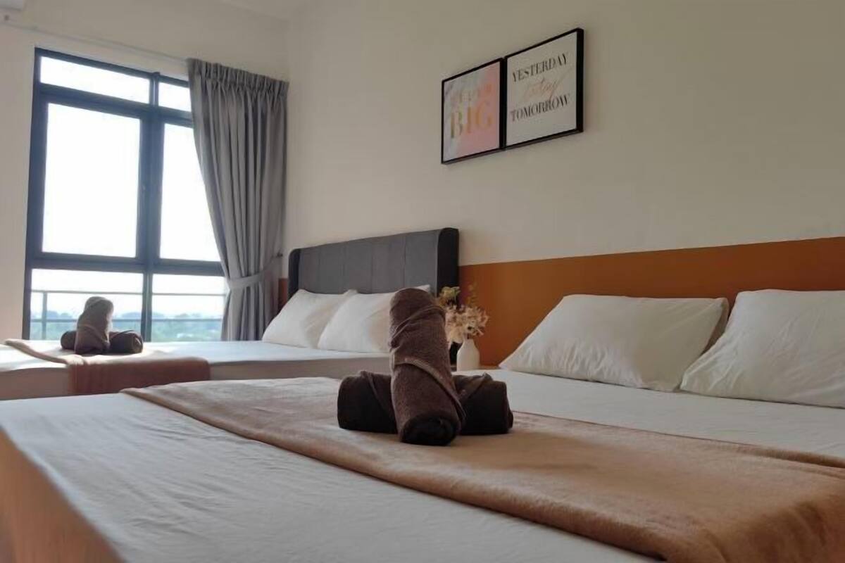A hotel room with two beds, a large window, and a motivational quote on the wall.
