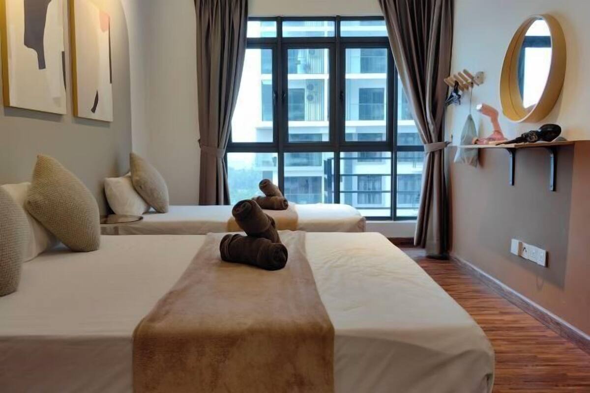 A hotel room with two beds, a large window, a mirror, and artwork on the wall.