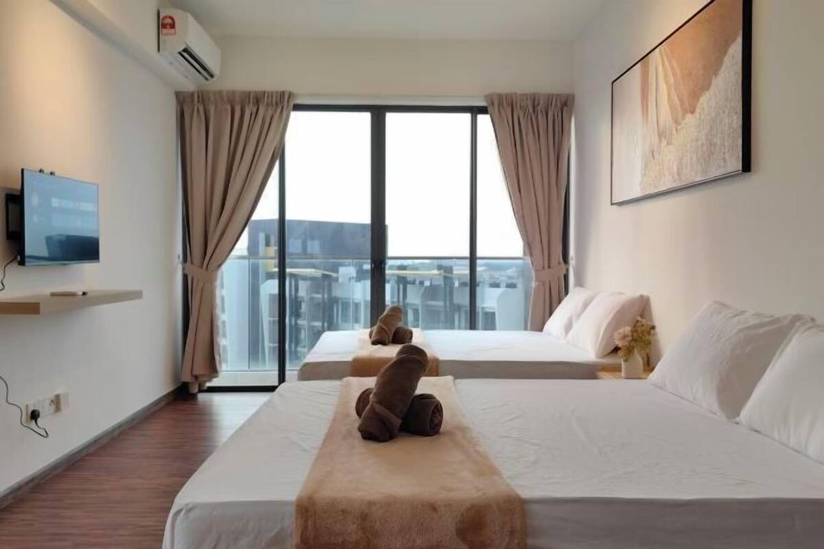 A hotel room with two beds, a mounted TV, and a large window with curtains.