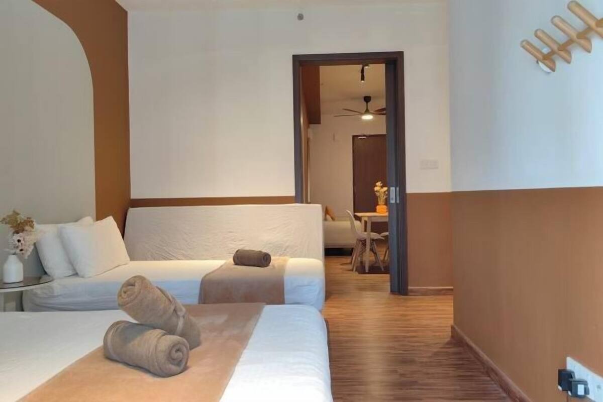 A hotel room with a bed, a small table, and a chair.