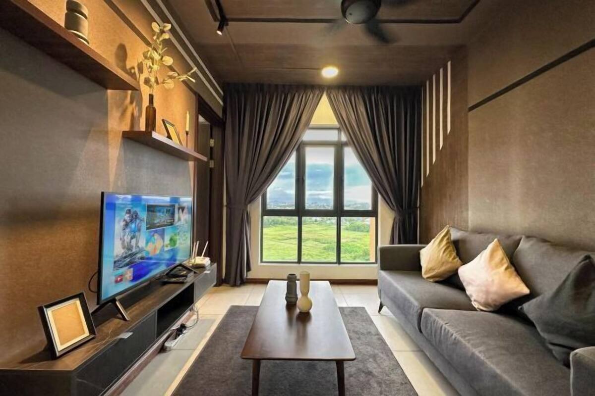 A modern living room with a television, a sofa, a coffee table, and a large window with curtains.