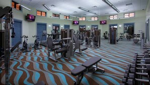 A gym with various exercise equipment, including treadmills, weight machines, and free weights.