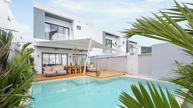 Ein moderner Poolbereich mit Sitzgelegenheiten und einer überdachten Terrasse.