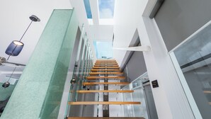 Ein modernes Interieur mit einer Glasstufenkonstruktion, weißen Wänden und einem Oberlicht.
