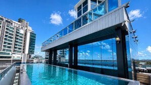 A rooftop infinity pool with a clear view of the ocean and surrounding buildings. - Semporna Lighthouse Hotel (Semporna)