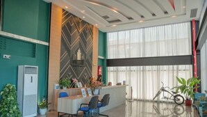 A modern reception area with a counter, chairs, and potted plants. - Semporna Lighthouse Hotel (Semporna)