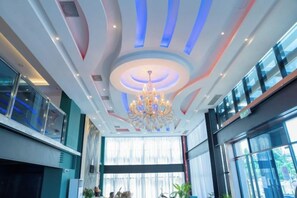 A hotel lobby with a modern chandelier, large windows, and a curved ceiling design. - Semporna Lighthouse Hotel (Semporna)