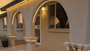 A building with a modern design, featuring arched windows and a pathway with gravel. - Ahwatukee Home-Mountain Views, Large Pool, Hiking, Peaceful, Clean & Comfortable (Phoenix)