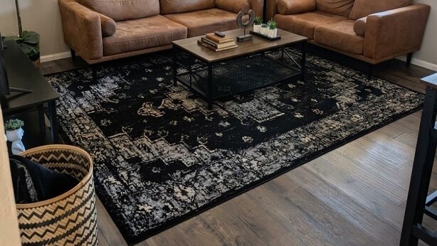 A living room with a sectional sofa, a coffee table, a black rug, and artwork on the wall. - Ahwatukee Home-Mountain Views, Large Pool, Hiking, Peaceful, Clean & Comfortable (Phoenix)