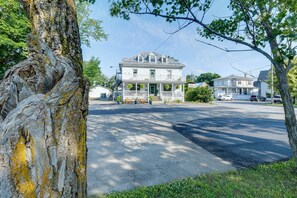 A two-story house with a porch, a garage, and a driveway. - Hôtel victoria (Saint-Pascal)