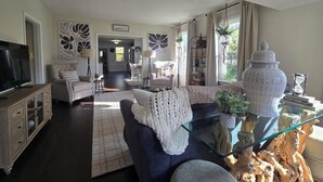 Una sala de estar con sofá, televisión y adornos.