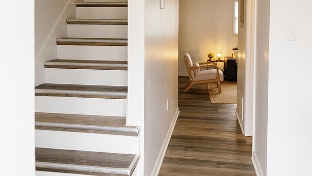 A staircase with wooden steps and a handrail, leading to a room with a desk and chair. - "Morning View 2" Cozy Modern Stay - College/Hiking (Berea)