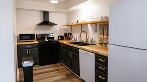 A compact kitchen with a microwave, stove, sink, and dishwasher. - "Morning View 2" Cozy Modern Stay - College/Hiking (Berea)