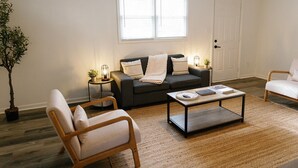 A living room with a sofa, armchair, coffee table, and a potted plant. - "Morning View 2" Cozy Modern Stay - College/Hiking (Berea)