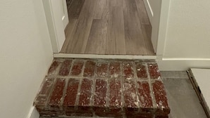 A hallway with a wooden floor, white walls, and a brick step at the bottom. - Charming 3-bedroom house with WiFi, AC , TESLA Charger in tranquil Lincoln City (Lincoln City)
