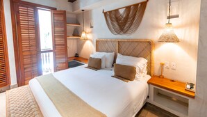Un dormitorio con una cama grande, cabecero de madera, mesitas de noche y lámparas colgantes.