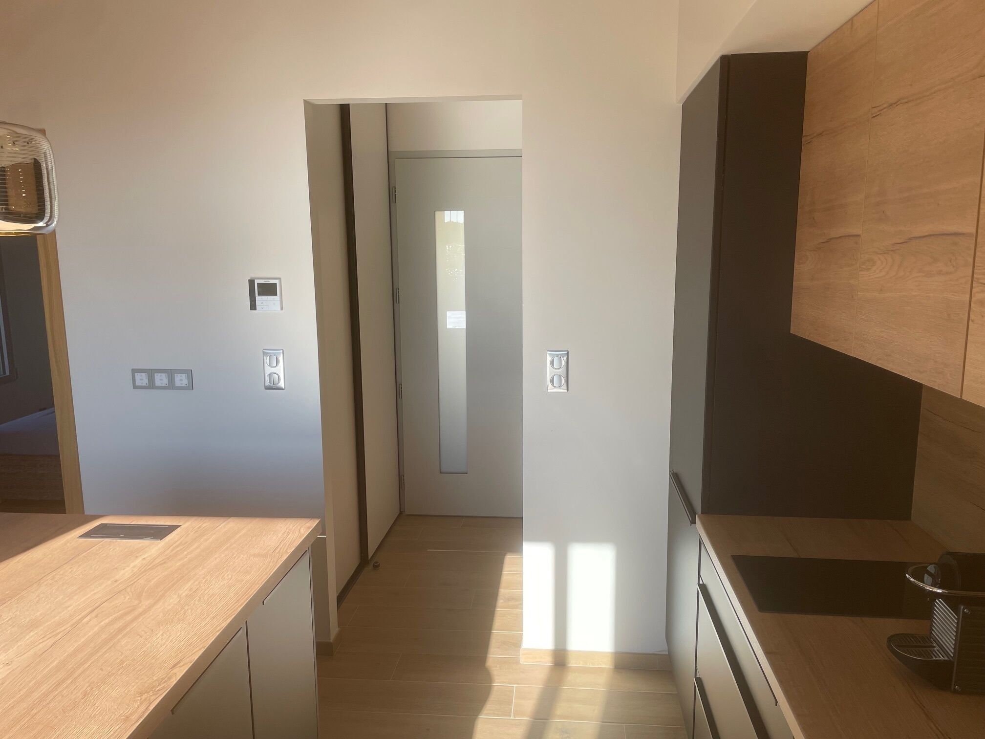 Eine moderne Küche mit Holzarbeitsplatten, einem Einbauofen und einem dunklen Holzschrank.