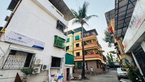 A narrow street with buildings, including a sign for Raksha Residency. - Hotel Raksha Residency (Navi Mumbai)