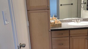 A bathroom with wooden cabinets, a sink, and a mirror. - Lovely 2-bedroom condo in Phoenix with WiFi and AC (Phoenix)