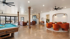 A spacious living area with a pool table, comfortable seating, and a fireplace. - The Red Mountain Suite @ HSRV (Ivins)