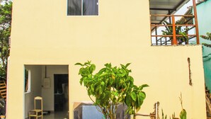 A two-story building with a flat roof, a small window on the upper floor, and a door on the ground floor. - Pousada Visual de Noronha (Fernando de Noronha)