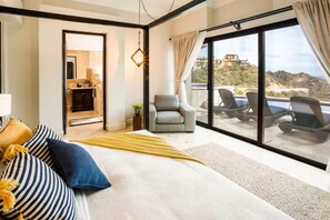 Relax in a stylish room with a large bed, armchair, and balcony access.