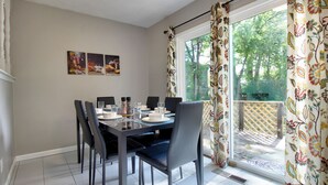 A dining area with a table set for four, chairs, and a window with floral curtains. - "Broken Arrow 3-Bedroom Retreat – Cozy, Family-Friendly with WiFi & AC!" (Broken Arrow)