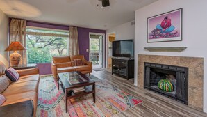 A living room with a sofa, coffee table, and fireplace. - Views of Ventana Canyon Golf course and Desert Sunsets!   (Tucson)