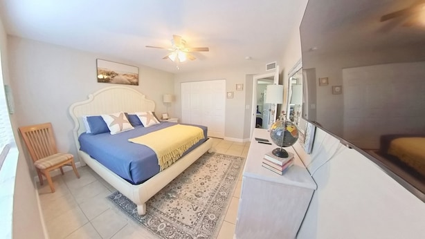 Une chambre à coucher comprenant un lit, une chaise, un bureau avec un globe terrestre et une armoire.