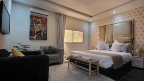 A hotel room with a bed, a TV, a couch, and a window. - Villa Dar sukar  (Marrakech)