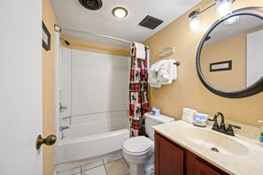 Une salle de bain équipée d’une baignoire, de toilettes, d’un lavabo et d’un miroir.