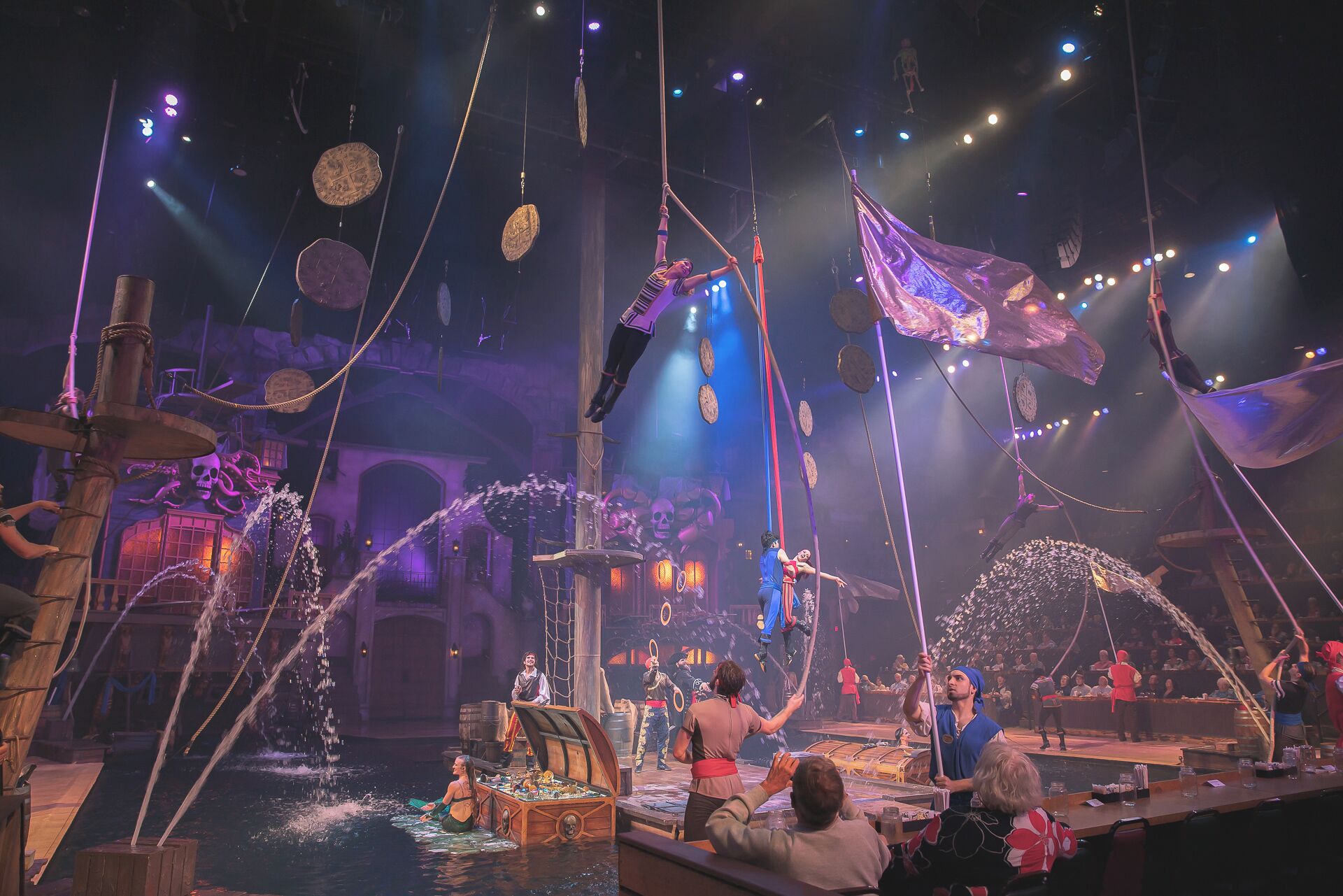 A stage with performers, a ship, and a pirate-themed backdrop.