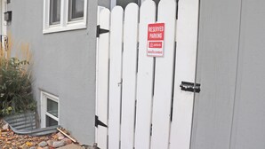 A white picket fence with a 'Reserved Parking' sign for Airbnb guests.