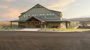 A large, single-story building with a gabled roof and a covered front porch. - The South Hills Suite @ HSRV  (Ivins)