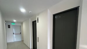 A corridor with doors, a sign indicating a room, and a light fixture on the ceiling. - Spacious and Luxurious -Stratum 6 (Manizales)
