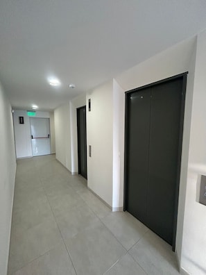 A corridor with doors, a sign indicating a room, and a light fixture on the ceiling. - Spacious and Luxurious -Stratum 6 (Manizales)