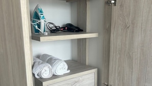 A wardrobe with a hanging shelf, a folded towel, and a pair of shoes. - Spacious and Luxurious -Stratum 6 (Manizales)