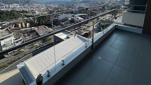 A balcony with a city view, including buildings and distant mountains. - Spacious and Luxurious -Stratum 6 (Manizales)
