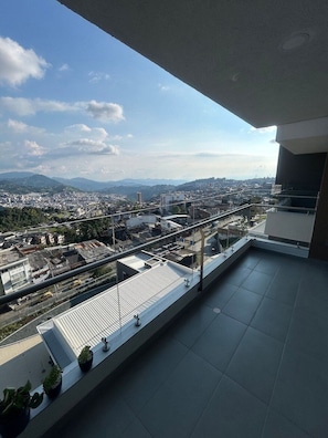 A balcony with a city view, including buildings and distant mountains. - Spacious and Luxurious -Stratum 6 (Manizales)
