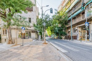 Eine Straße mit Gebäuden, Bäumen und einer Fußgängerüberweg.