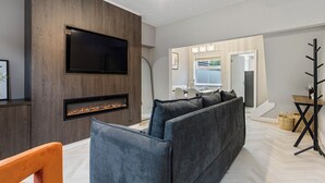 A modern living room with a built-in TV, fireplace, and a sectional sofa. - 29 Carleton Street · Newly Refurbished 2-Bed Terraced Home in York - Pass the Keys (York)