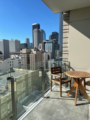 Relax on the balcony with a city view, featuring a table and chairs for dining or unwinding.