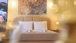 A neatly made bed with white linens and pillows, a headboard, and a wall-mounted artwork above. - Blue Ark Acropolis Signature Residence (Athens)