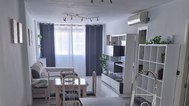 A modern kitchen with a central island, bar stools, and a built-in sink.