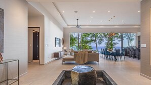 A spacious living area with a modern design, a dining area, and a view of the outdoors.